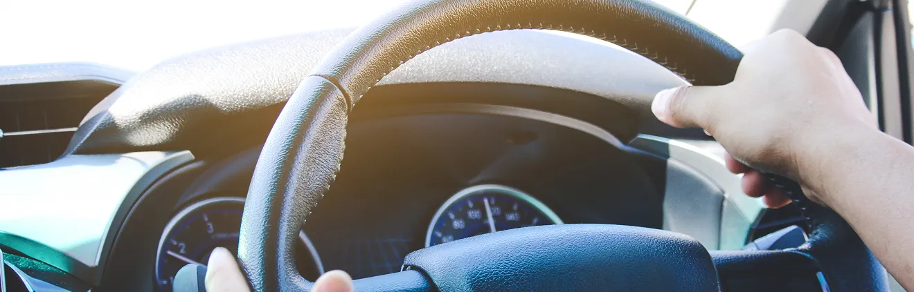 車のハンドルを握る手の画像
